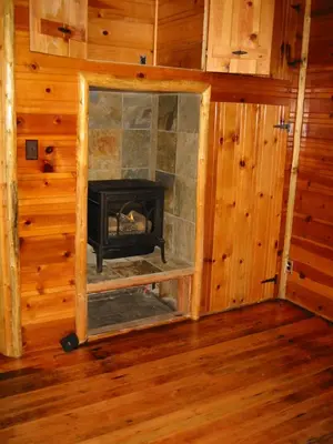 a fireplace in a log cabin with a mirror at Tahoma Meadows - Sugar Pine Cabin in Tahoma