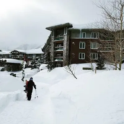 a person walking through the snow in front of a building at Juniper Springs Lodge #238 in Mammoth Lakes