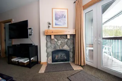 a living room with a fireplace and a television at Juniper Springs Lodge #543 in Mammoth Lakes