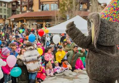 a crowd of people in a parade with an elephant at Juniper Springs Lodge #543 in Mammoth Lakes