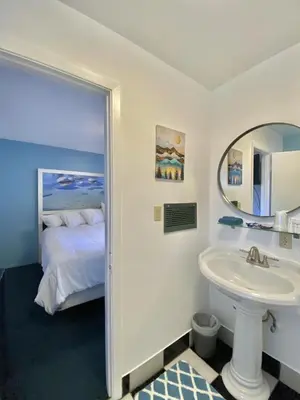 a bathroom with a bed and a sink and a mirror at Bluebird Day Inn & Suites in South Lake Tahoe
