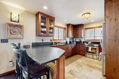 a kitchen with wooden cabinets and a black counter top at Sophisticated Northstar Mountain Retreat in Truckee