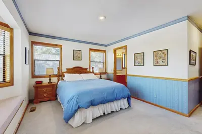 a bedroom with a blue bed and windows at Tuna Bush in Truckee