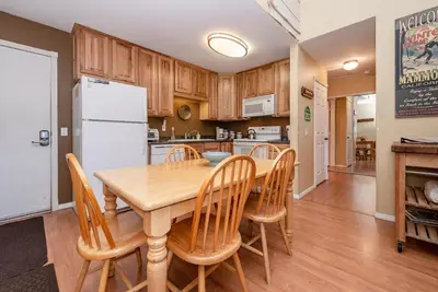 a kitchen and dining room with a wooden table and chairs at Summit B- # 257 in Mammoth Lakes