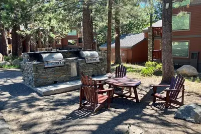 a picnic table and chairs and a grill in a yard at The Summit 276 in Mammoth Lakes