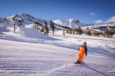 a man is skiing down a snow covered slope at The Summit 276 in Mammoth Lakes