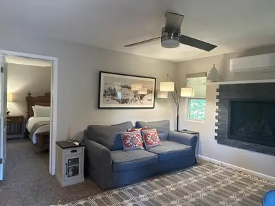 a living room with a blue couch and a fireplace at YoBee! Park Reservation Included! Heart of Yosemite - Homey Studios and Breakfast in Yosemite West