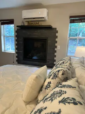 a bed with pillows in front of a fireplace at YoBee! Park Reservation Included! Heart of Yosemite - Homey Studios and Breakfast in Yosemite West