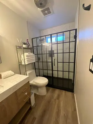 a bathroom with a toilet and a glass shower door at YoBee! Park Reservation Included! Heart of Yosemite - Homey Studios and Breakfast in Yosemite West