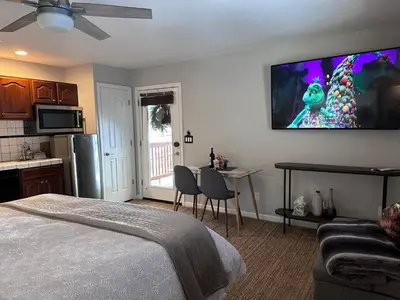 a bedroom with a bed and a tv on the wall at YoBee! Park Reservation Included! Heart of Yosemite - Homey Studios and Breakfast in Yosemite West