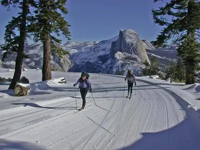 two people are cross country skiing in the snow at Oak Retreat by Yosemite National Park in Coarsegold
