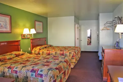 a hotel room with two beds and green walls at Hawthorne's Best Inn in Hawthorne