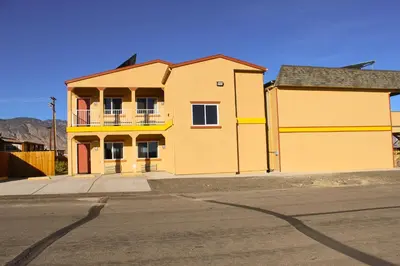 a yellow house on the side of a street at Hawthorne's Best Inn in Hawthorne