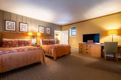 a hotel room with two beds and a flat screen tv at The Ahwahnee in Yosemite Village