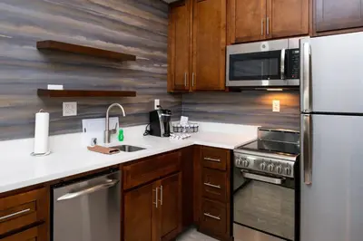 a kitchen with wooden cabinets and a stainless steel refrigerator at Residence Inn Visalia in Visalia