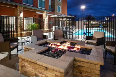 a patio with a fire pit and a pool at Residence Inn Visalia in Visalia