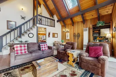 a living room with two couches and a staircase at Tallac Views Getaway in South Lake Tahoe