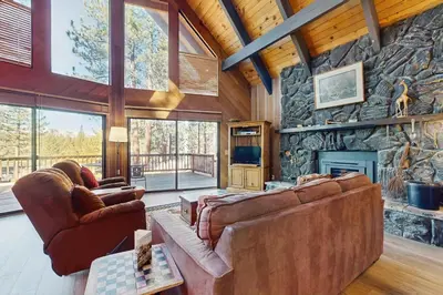 a living room with couches and a stone wall at Tallac Views Getaway in South Lake Tahoe