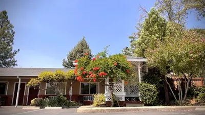 a house with flowers in the front of it at Mariposa Lodge in Mariposa