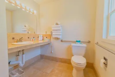 a bathroom with a toilet and a sink and a mirror at Mariposa Lodge in Mariposa