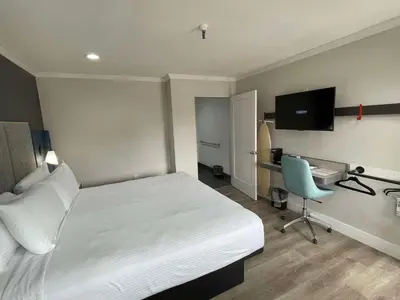 a bedroom with a bed and a desk with a computer at The Midtowner Hotel, SureStay Collection by Best Western in Sacramento