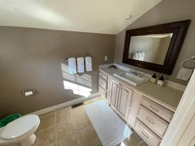 a bathroom with a toilet and a sink and a mirror at Yosemite Basecamp in Groveland
