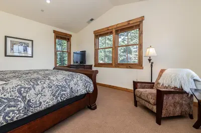 a bedroom with a bed and a chair and a television at Creekhouse 1312 in Mammoth Lakes