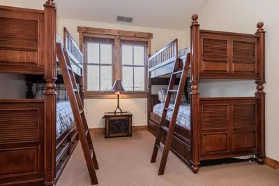 a bedroom with three bunk beds and a window at Creekhouse 1312 in Mammoth Lakes