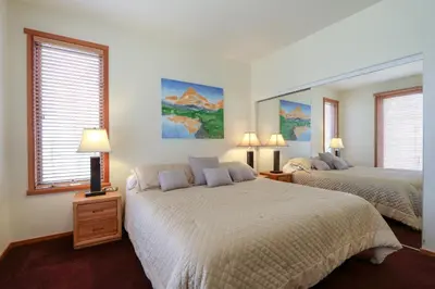 a bedroom with two beds and two windows at Snowcreek V #999 condo in Mammoth Lakes