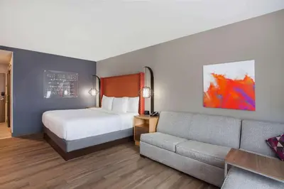 a hotel room with a bed and a couch at La Quinta by Wyndham Madera in Madera