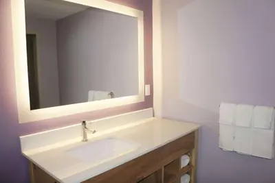 a bathroom with a sink with a mirror and towels at La Quinta by Wyndham Madera in Madera