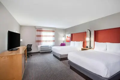a hotel room with two beds and a flat screen tv at La Quinta by Wyndham Madera in Madera