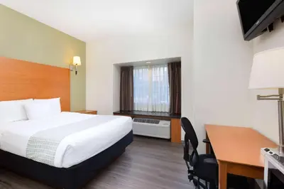 a hotel room with a bed and a desk and a desk at La Quinta by Wyndham Tulare in Tulare