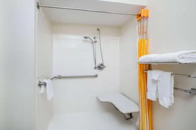 a small bathroom with a shower and a toilet at La Quinta by Wyndham Tulare in Tulare
