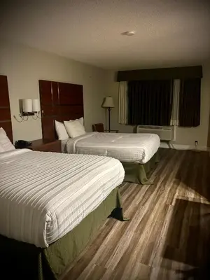 two beds in a hotel room with wooden floors at Western Holiday Lodge in Three Rivers