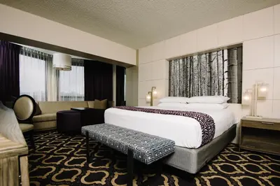 a hotel room with a large bed and a couch at Harrah's Lake Tahoe, A Caesars Destination in Stateline
