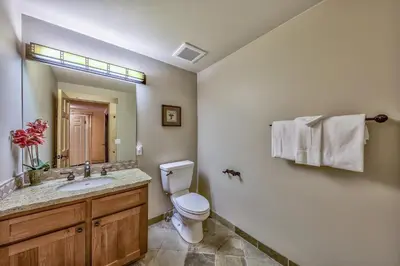 a bathroom with a toilet and a sink and a mirror at Three-Bedroom Townhouse in Kirkwood