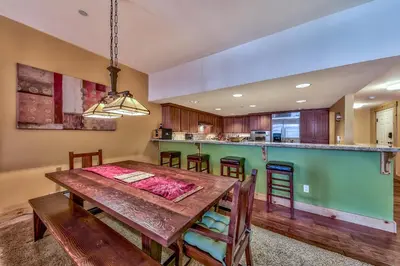a dining room and kitchen with a wooden table and chairs at Three-Bedroom Townhouse in Kirkwood