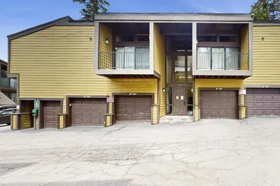 a yellow house with two garage at Scott Peak Views in Alpine Meadows