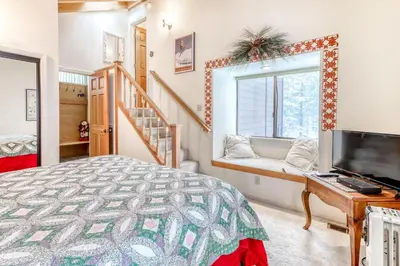 a bedroom with a bed and a flat screen tv at Northstar Condo in the Trees in Truckee