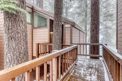 a deck in the woods with snow on the ground at Northstar Condo in the Trees in Truckee