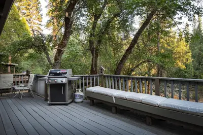 a grill and a bench on a wooden deck at 43 The Last Resort in Wawona