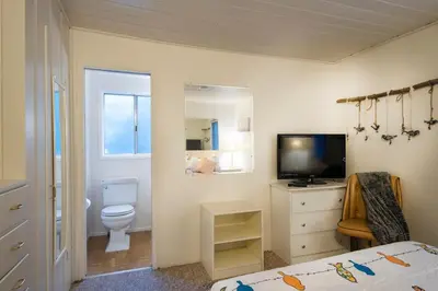 a bedroom with a bed and a toilet and a television at 43 The Last Resort in Wawona