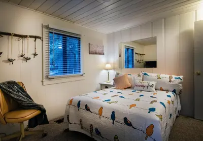 a bedroom with a bed and a chair and a mirror at 43 The Last Resort in Wawona