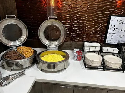 a buffet with bowls of food on a counter at Heritage Inn - Yosemite/Sonora in Sonora