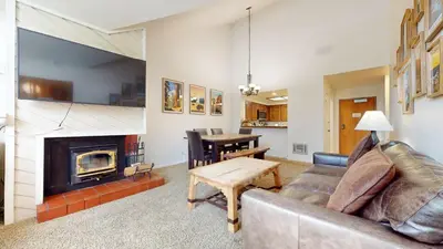 a living room with a couch and a fireplace at Aspen Creek #311 condo in Mammoth Lakes