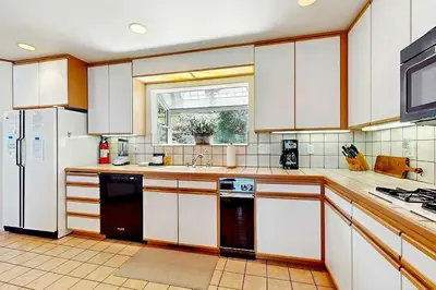 a large kitchen with white cabinets and a window at Sleek Hill Haven with Martis Valley Views in Polaris