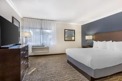 a hotel room with a bed and a flat screen tv at Best Western Town & Country Lodge in Tulare