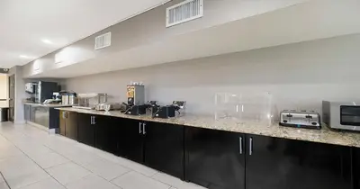 a kitchen with black cabinets and a counter top at SureStay Plus Hotel by Best Western Rocklin in Rocklin