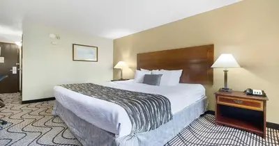 a hotel room with a large bed and a table at SureStay Plus Hotel by Best Western Rocklin in Rocklin